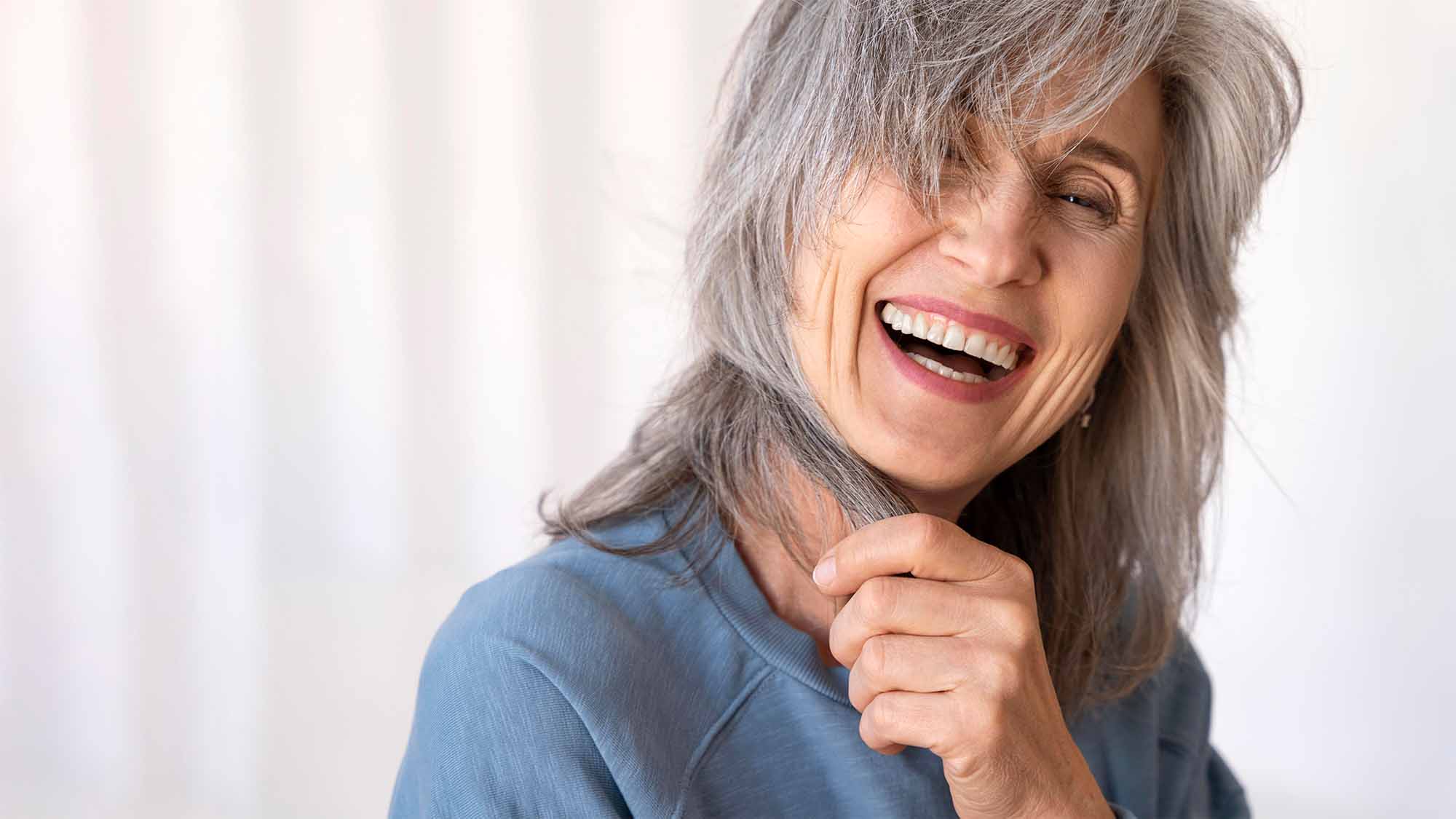 mujer sonriendo con implantes dentales cuidados